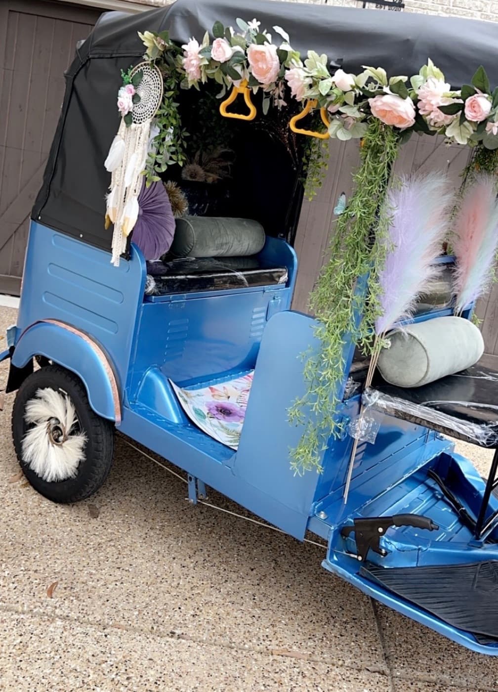 The rickshaw dressed in premium florals from the side, the decoration option priced as an add-on