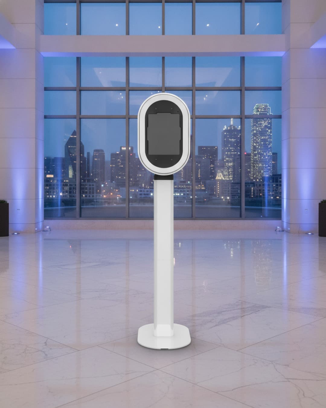 White oval photo booth on a slim stand in a marble hotel foyer with a Dallas skyline at dusk